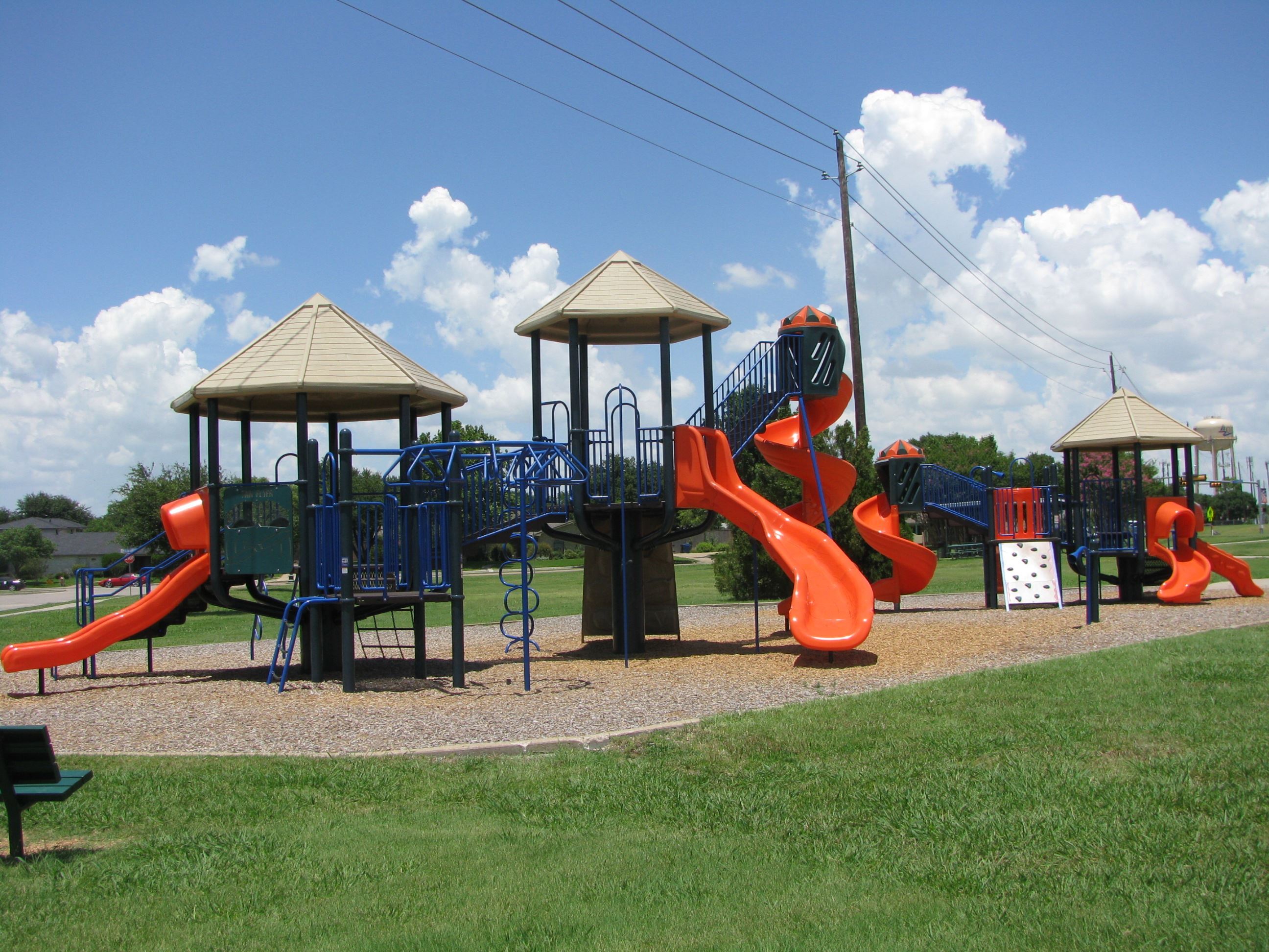 Large playground with orange slides and climbing structures